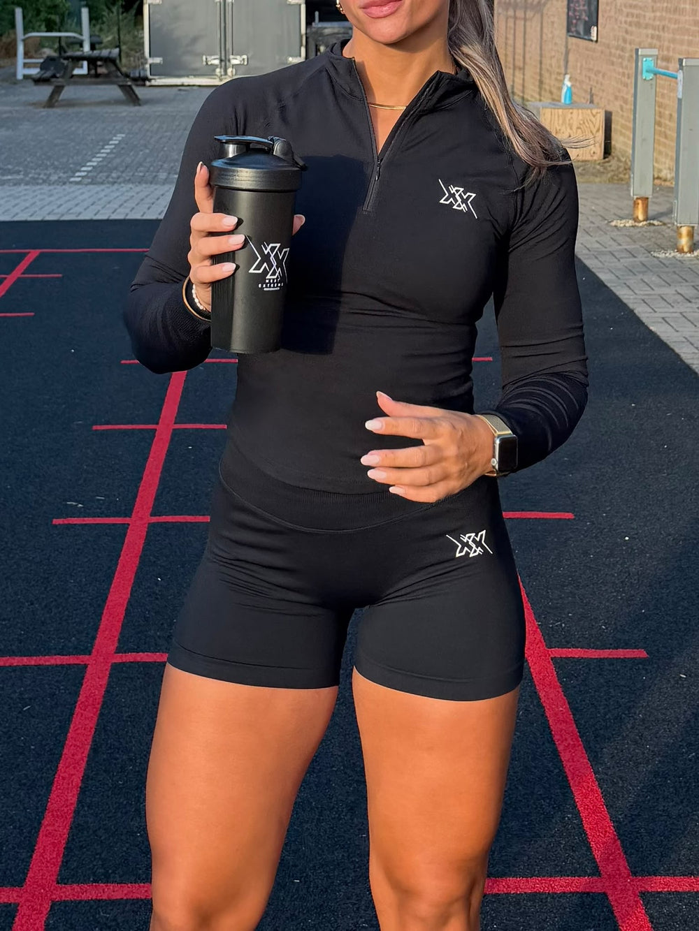 Atlete in de Crop Zipper en Shorts 4.5 inch in Ultra Black met shaker op de baan