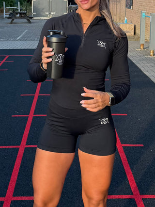 Atlete in de Crop Zipper en Shorts 4.5 inch in Ultra Black met shaker op de baan