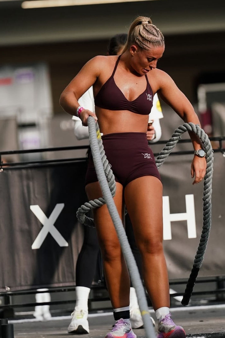 Atlete met battle ropes tijdens HYROX, in Dark Coffee