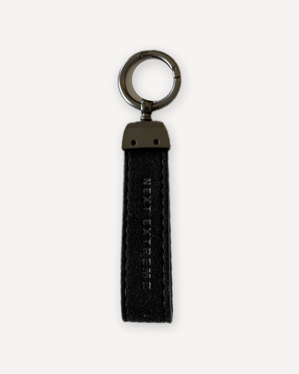 Achterkant van de XX Keychain met gedeboste merknaam op zwart microvezel